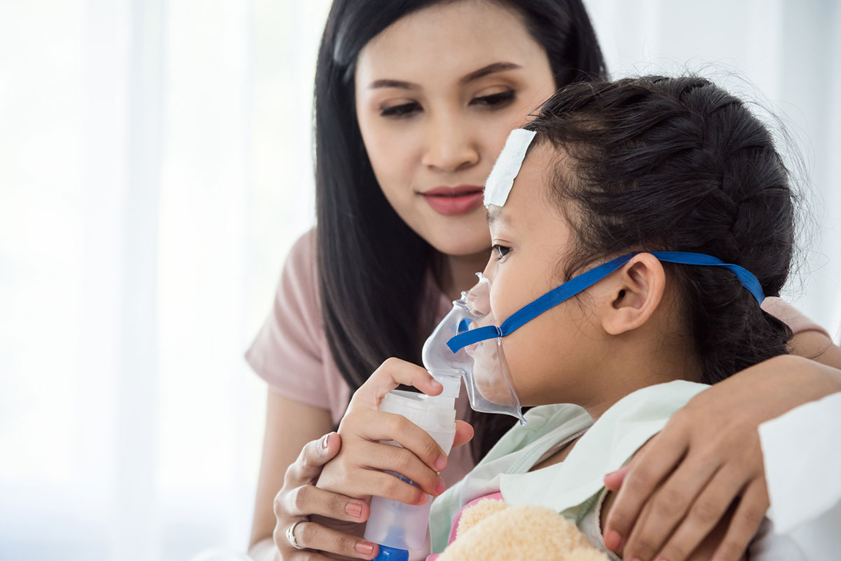 Child using oxygen nebulizer mask with parent's support during medical treatment covered by ASEBP retirement health benefits