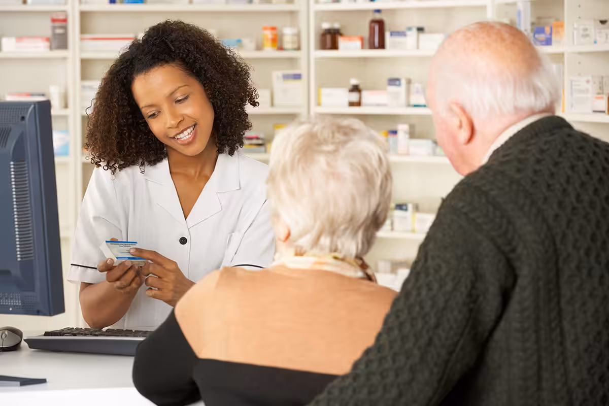 Retired couple consulting pharmacist about maintenance medication program and prescription drug coverage