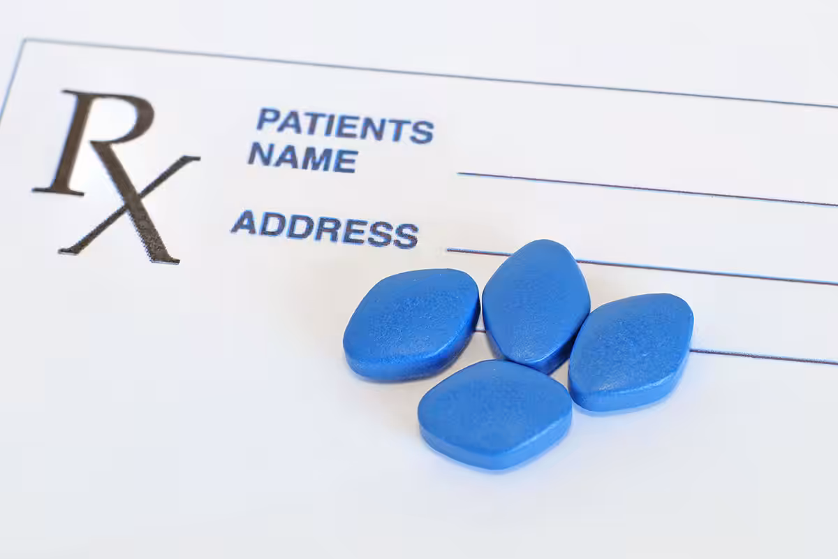 Four blue prescription tablets on a blank Rx pad representing sexual dysfunction medication coverage under ASEBP MyRetiree Plan