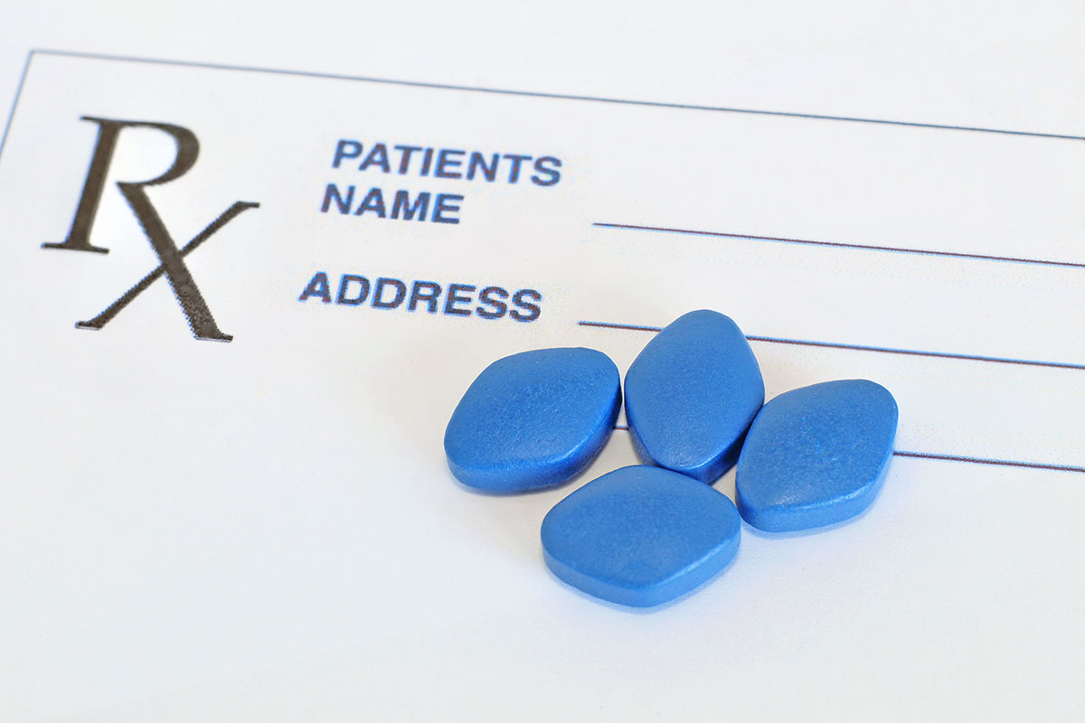 Four blue prescription tablets on a blank Rx pad representing sexual dysfunction medication coverage under ASEBP MyRetiree Plan