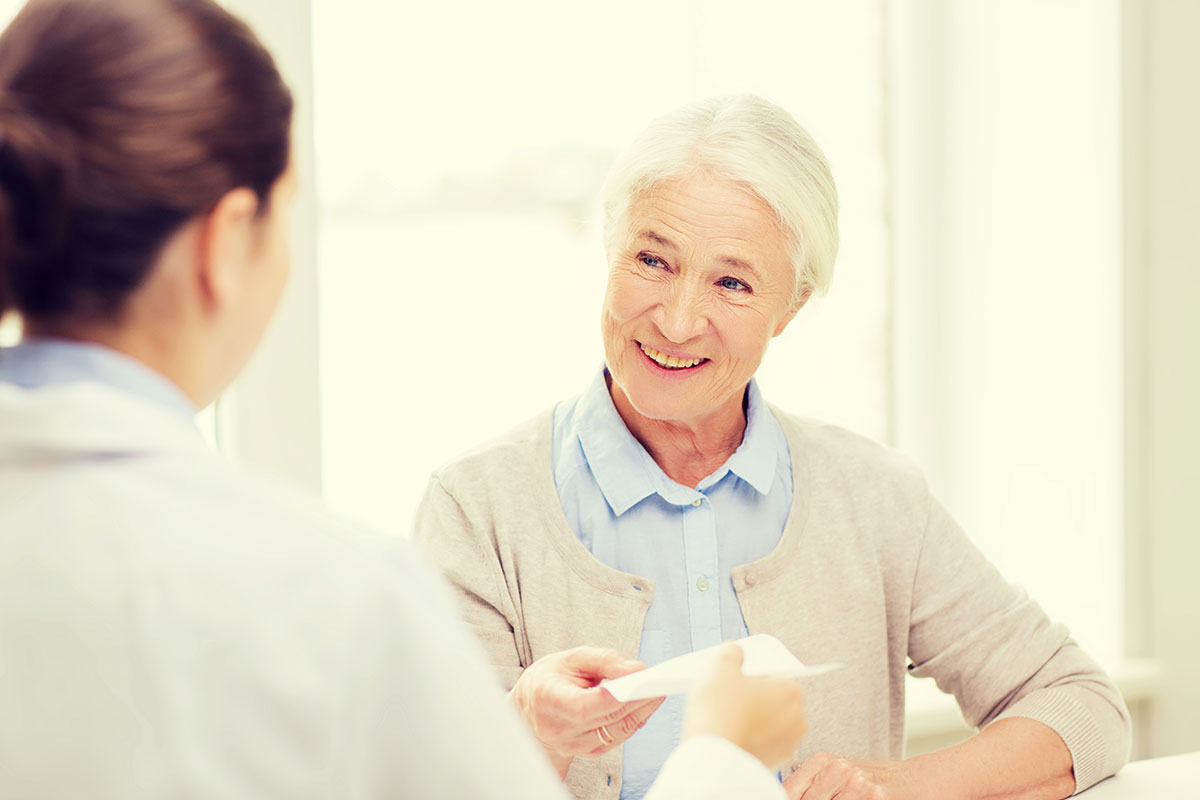 Retiree reviewing life-sustaining medication exceptions with healthcare provider for ASEBP drug coverage