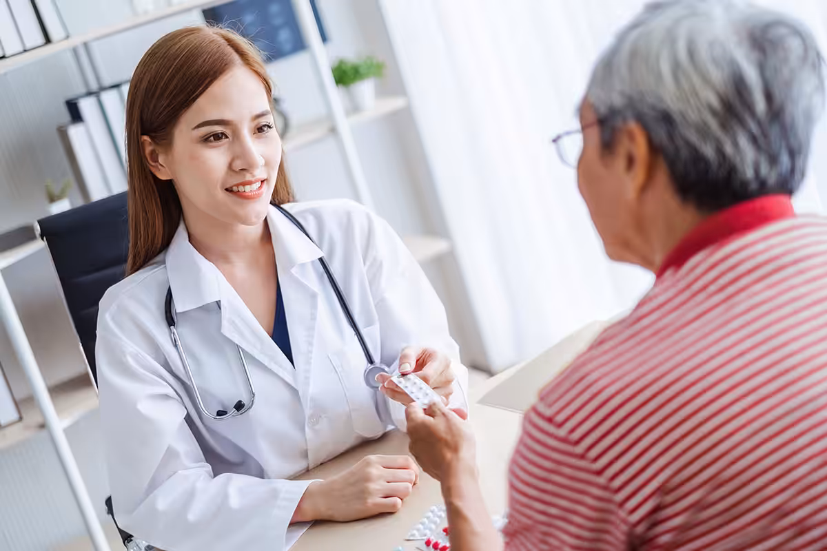 Healthcare provider guiding retired Alberta educator through first-line medication options for prescription drug plan