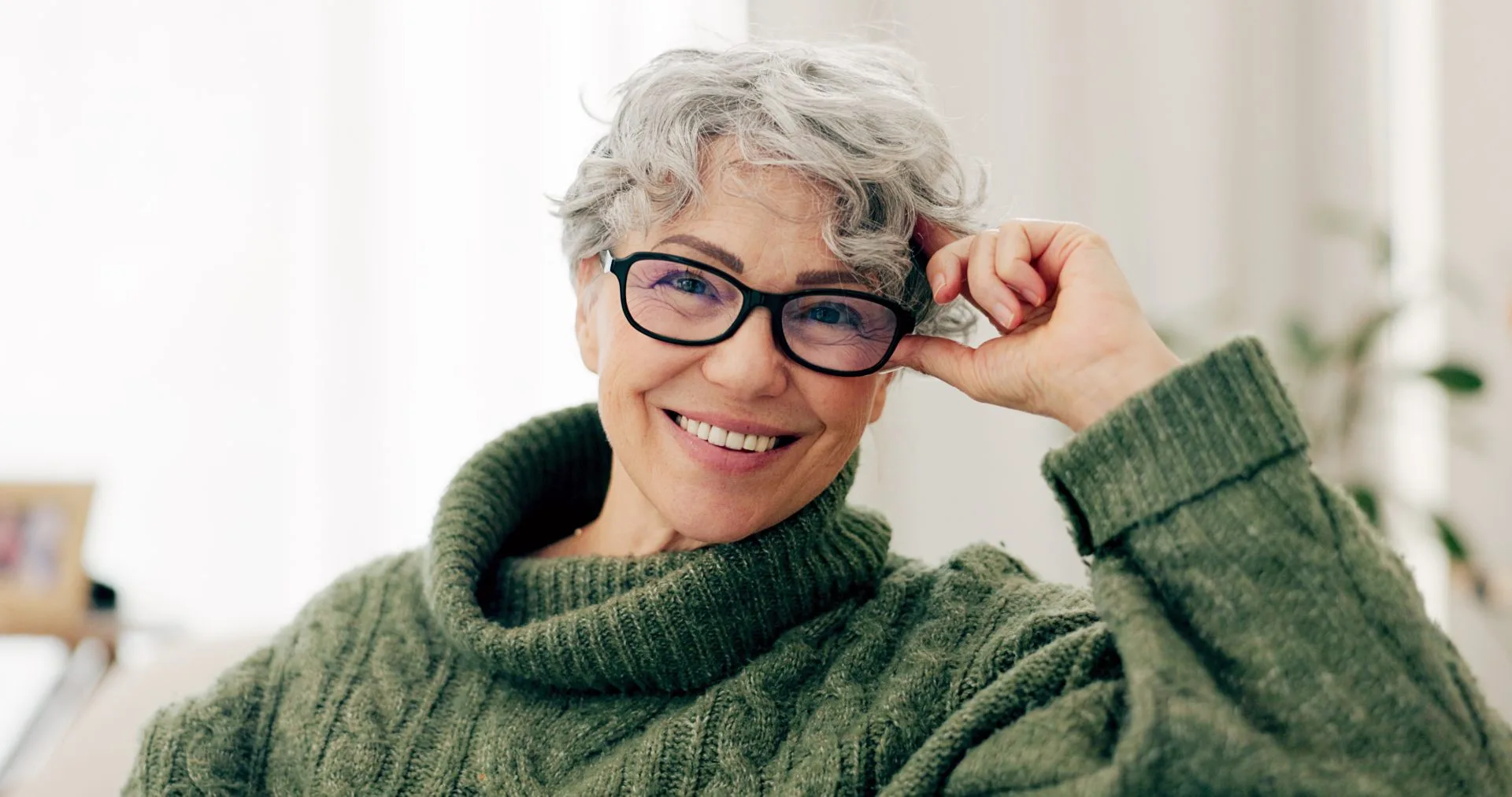 Smiling retired Alberta educator adjusting glasses, representing ASEBP MyRetiree Plan members at retirement events